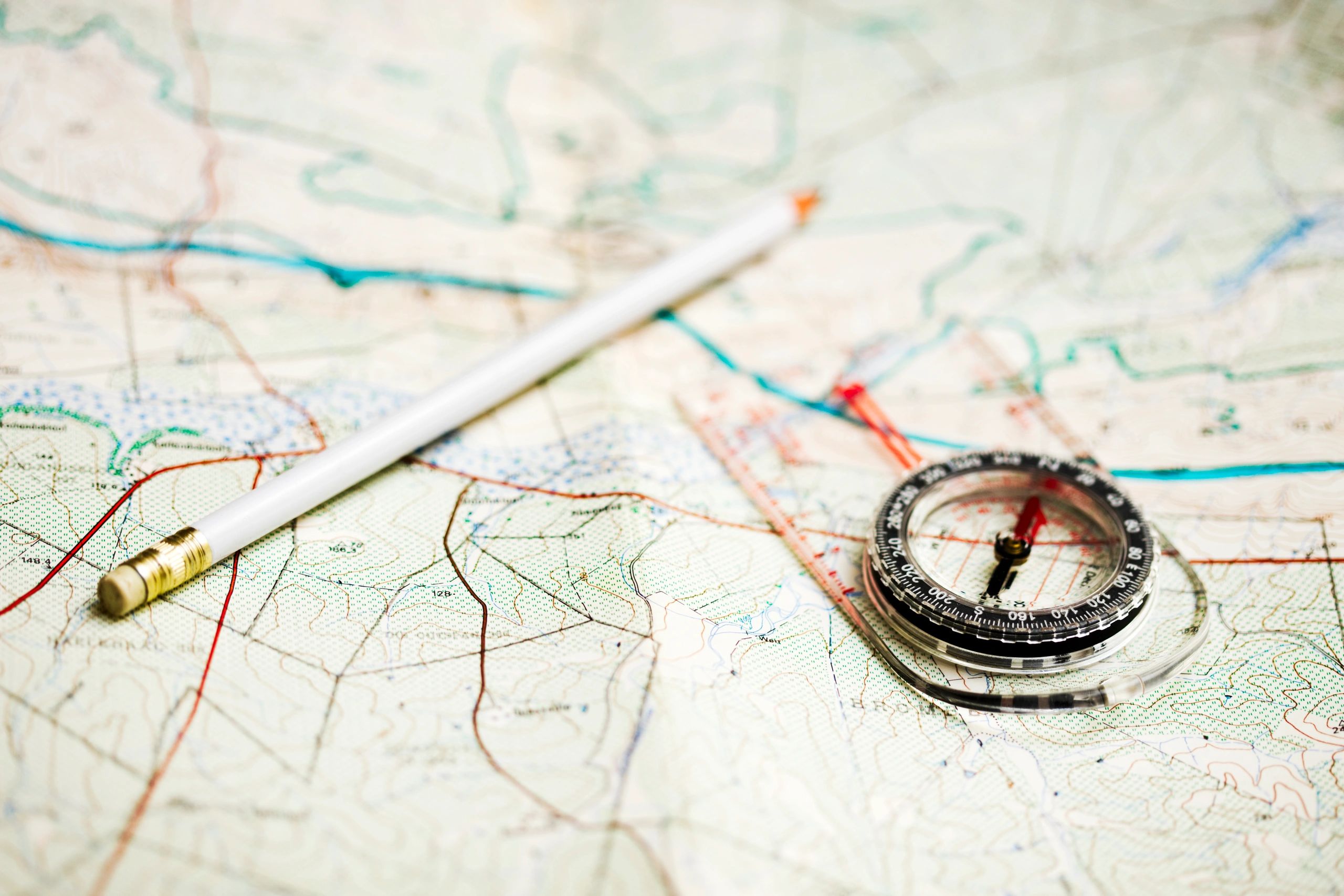 Topographic map, pencil, and compass for route planning