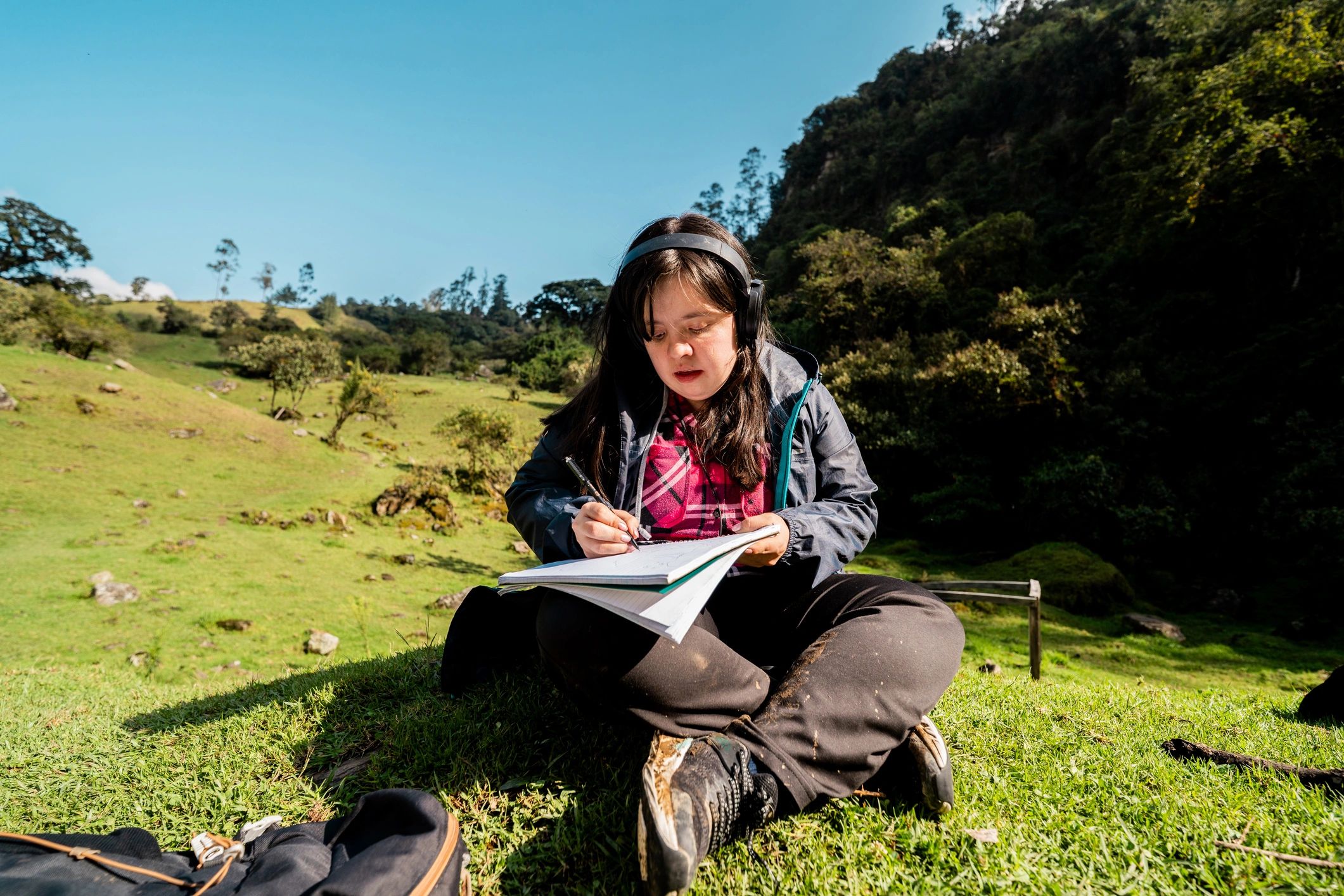 Person writing notes outdoors in nature