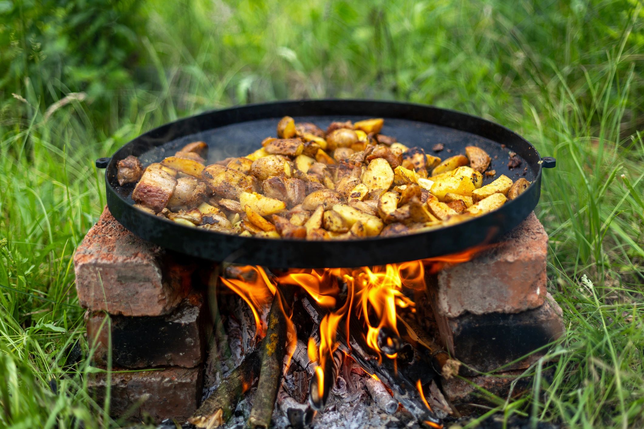 Food frying in a pan over open fire